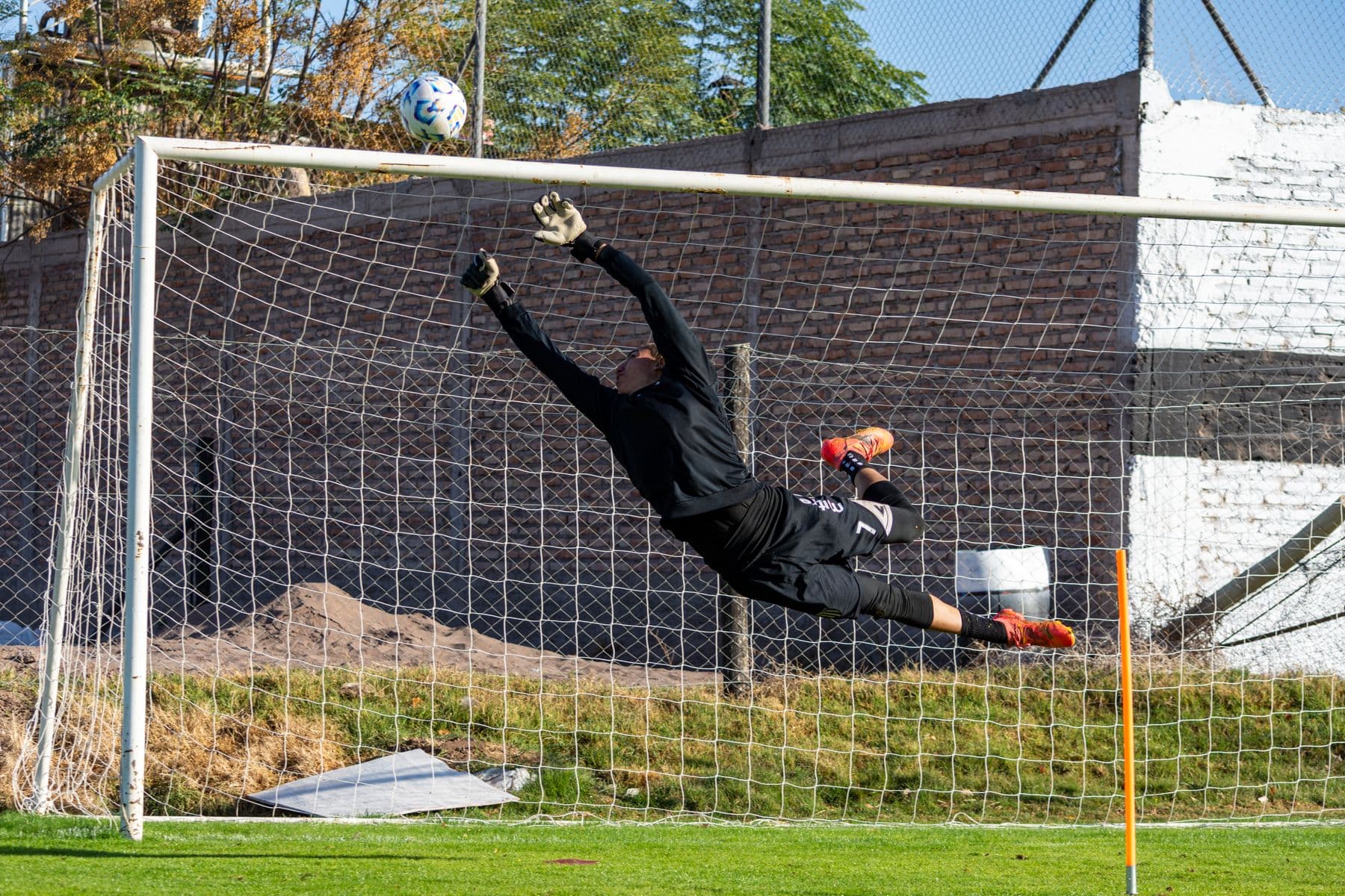A goalkeeper leaping to make a save during an amateur football match
